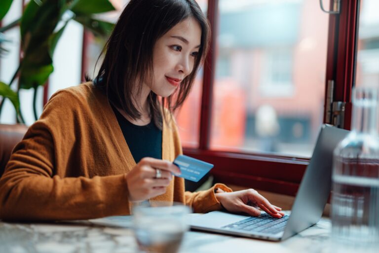 Young Woman Holding Credit Card Computer