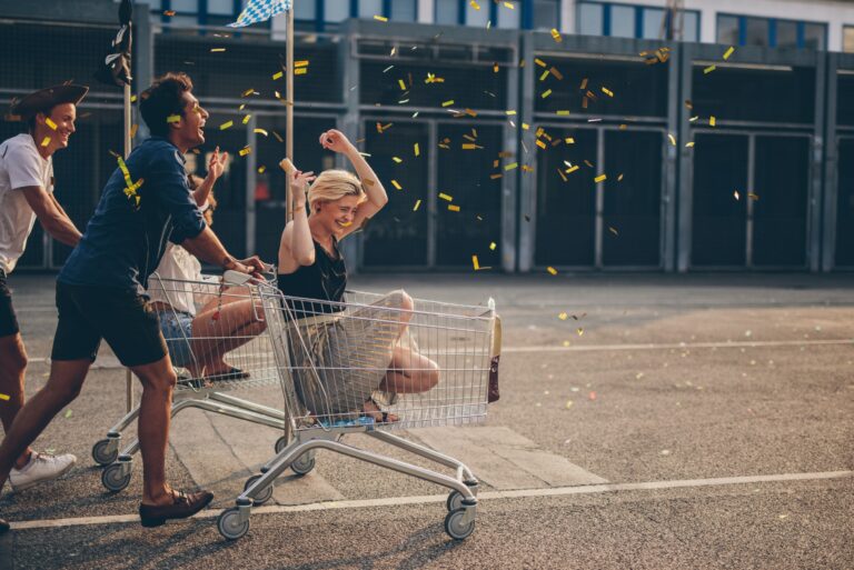 Young Adults Riding Shoppingcarts Celebrating Confetti