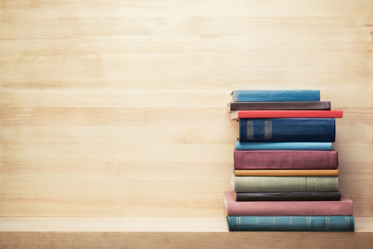 Books On Wooden Shelf Piled Stacked