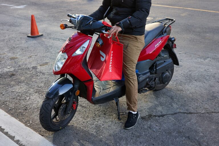 Man Scooter Holding Doordash Bag