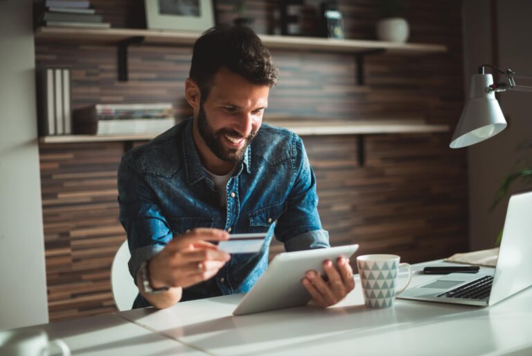 Smiling Man Holding Laptop Credit Card